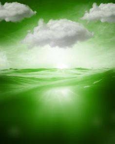 an image of the ocean with clouds and sun shining through it's green water