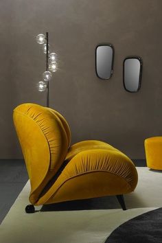 a yellow chair sitting on top of a white rug next to a wall mounted mirror