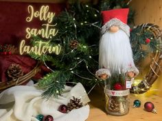 a santa clause doll sitting on top of a table next to pine cones and christmas decorations