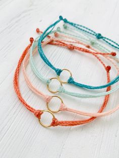 These fun bracelets are waterproof and great for anyone who is often doing outdoor activities. They would make a nice gift. Stack these together, with other bracelets, or wear them by themselves! They are perfect for everyday wear! ∙ ∙ ∙ ∙ ∙ ∙ ∙ ∙ ∙ ∙ ∙ ∙ ✦ MATERIALS ✦ * High-Quality Waxed Polyester Cord * Open Circle Charms ∙ ∙ ∙ ∙ ∙ ∙ ∙ ∙ ∙ ∙ ∙ ∙ ✦ SIZES ✦ These bracelets are adjustable from about 5.5 Inches to 8.5 Inches. They are made to order so if you need a custom size please let me know. I'm happy to do that for you.  ∙ ∙ ∙ ∙ ∙ ∙ ∙ ∙ ∙ ∙ ∙ ∙ ✦ PLEASE NOTE ✦ When you first receive this bracelet, it may feel slightly waxy, which may make it more difficult to adjust. The waxy texture does not last. After a day or two of wearing, the waxy texture will fade, and it will be much easier t How To Make Waxed Cord Bracelets, How To Make Wax Cord Bracelets, Wax String Bracelet Ideas, Wax Bracelet Ideas, Wax Cord Bracelet Diy, Wax Bracelets, Wax String Bracelets, Waxed Cord Bracelets, Puravida Bracelets