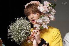 a person with flowers on their head and a teddy bear in front of them,