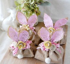 two paper flowers sitting on top of brown bags