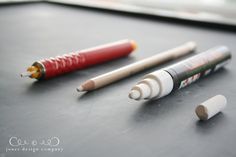 three different colored pencils sitting next to each other