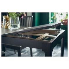 a table with an open drawer on it in the middle of a dining room area