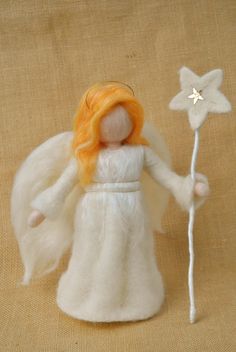 an angel doll with orange hair holding a star