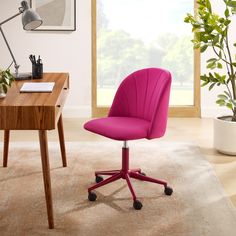 a pink office chair sits in front of a desk with a potted plant on it