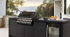 an outdoor kitchen with grill, sink and counter top area in front of the window