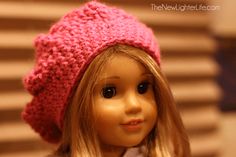 a doll with blonde hair wearing a pink knitted beanie hat on her head