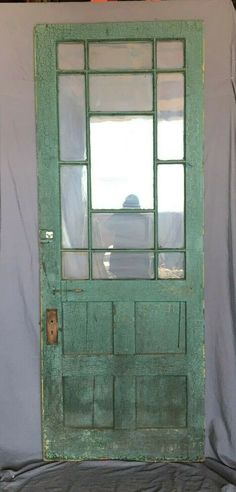 an old green door with glass on it