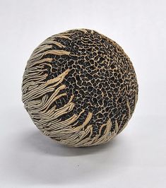 a decorative object is sitting on a white surface with black and gold details in the center