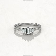 a three stone diamond ring on a white background with shadow from the side, in front of it