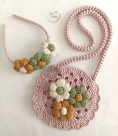 a crocheted bag with flowers on it and a lanyard attached to the strap