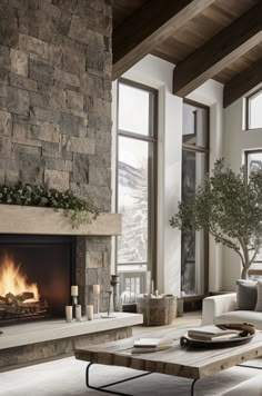 a living room filled with furniture and a fire place in front of a stone wall