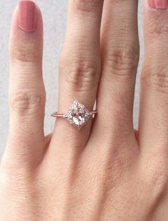 a woman's hand with a ring on it and a diamond in the middle