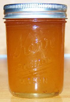 a glass jar filled with liquid sitting on top of a wooden table