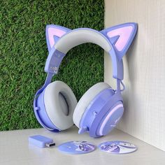 a pair of headphones sitting on top of a table next to a green wall