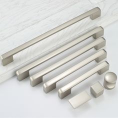 an assortment of handles and knobs on a white counter