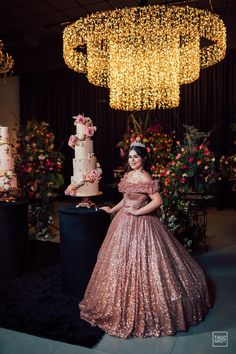 a woman in a pink dress standing next to a cake