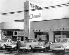 an old black and white photo of cars parked in front of a store