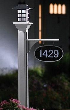 a lamp post with a house number sign on it