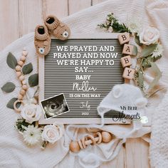 a baby announcement surrounded by flowers and other items on a white blanket with the words, we pray and prepare to wede happy to say my baby