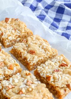 several pieces of granola bar sitting on top of a white paper towel next to a blue and white checkered napkin