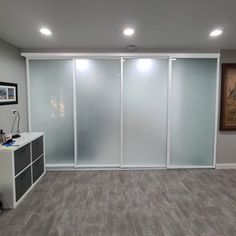 an empty room with sliding glass doors on the wall and wood flooring in front of it