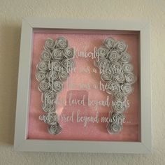 a frame with some paper roses in the shape of a heart and words on it