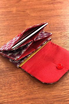 a red wallet sitting on top of a wooden table