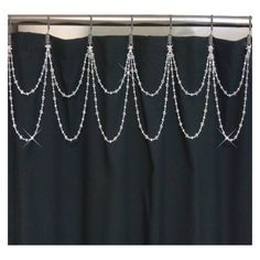 a shower curtain with chains hanging from it's side and black curtains in the background