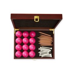 a wooden box filled with pink balls and chopsticks