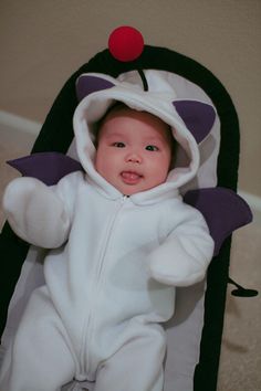 a baby in a costume laying on the floor