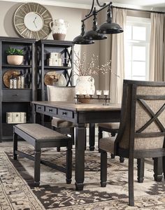 a dining room table with two chairs and a bench in front of it on an area rug