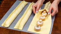 a person is making doughnuts on a sheet of wax paper with their hands