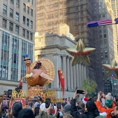 people are taking pictures of floats in the air on a city street with tall buildings