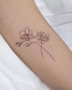 a small flower tattoo on the arm