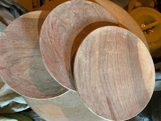 three wooden discs sitting on top of each other in front of a pile of wood