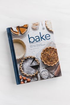 a cookbook with baked goods on it sitting on top of a white countertop