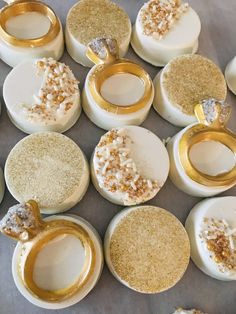 several different types of wedding rings on top of white plates with gold rims and sprinkles