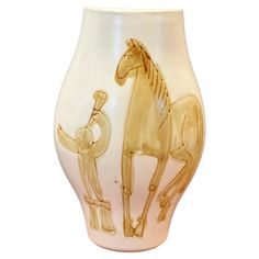 a white and gold vase with an image of a horse on it's side