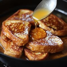 the french toast is being poured with syrup