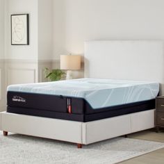 an image of a mattress in the middle of a room with a white headboard