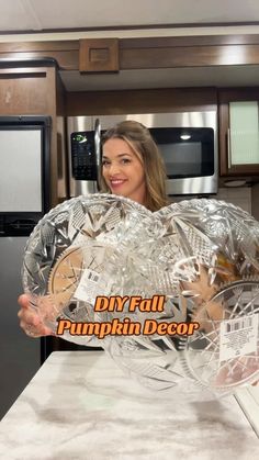 a woman holding up a large glass plate in front of her face with the words diy fall pumpkin decor on it