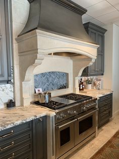 a stove top oven sitting inside of a kitchen next to an oven and countertop