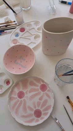 there are some paint brushes and bowls on the table with other things to draw in it