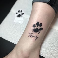 a small paw print on the ankle that says, riley with an animal's name underneath it