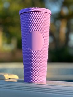 a pink cup sitting on top of a table