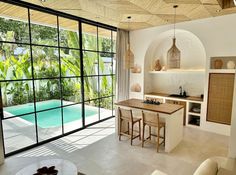 an open kitchen and living room area with sliding glass doors that lead to the pool