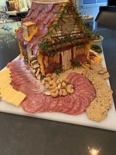 a platter with meats, cheese and crackers on it is sitting on a table