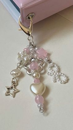 a close up of a key chain on a table near a pink box and other items